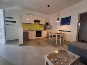 a kitchen and a living room with a table and a couch at Apartman Vitamare 160 m from the beach in Novi Vinodolski
