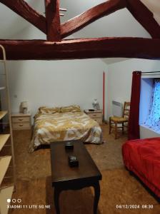 a bedroom with a bed and a table and a tv at Maison de vacances individuelle toute équipée in Dampierre-sous-Bouhy