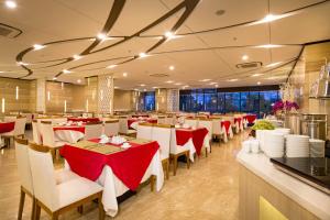 un ristorante con tavoli e sedie rossi e bianchi di Stella Maris Nha Trang Hotel a Nha Trang