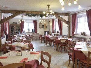 a restaurant filled with tables and chairs with red and white tablecloths at Rifugio Fedaia in Malga Ciapela