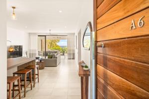 an open kitchen and living room with a wooden door at Bluepearl, Sileview Residence in Rivière Noire