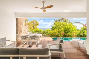 an outdoor patio with a table and chairs and a pool at Bluepearl, Sileview Residence in Rivière Noire