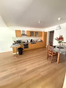 a kitchen with wooden cabinets and a table and chairs at L échappée verte - 6 voyageurs - 2 chambres in Barr