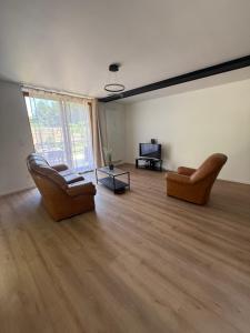 an empty living room with two chairs and a television at L échappée verte - 6 voyageurs - 2 chambres in Barr