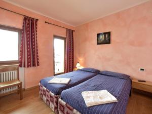 a bedroom with a blue bed and a window at Rifugio Fedaia in Malga Ciapela