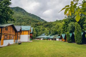 una fila di case con montagne sullo sfondo di Rafting Kamp Mačak a Foča