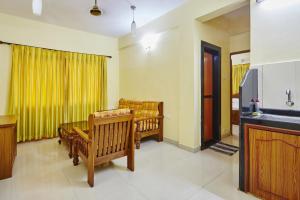 a living room with chairs and a yellow curtain at Saikunj Holiday Homes in Candolim