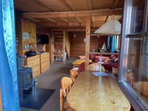 a living room with a wooden table in a cabin at Feriendomizil Haus Störtebeker in Spieka-Neufeld