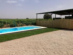 a swimming pool in a yard with a wooden fence at Casa Rural La Navarra in Villarrobledo