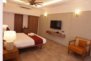 une chambre avec un lit et une télévision à écran plat dans l'établissement Arabian Pearl Beach Resort Cherai, à Cochin