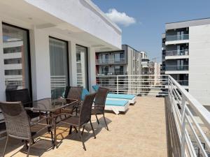 ein Balkon mit Tisch und Stühlen auf einem Gebäude in der Unterkunft Resort Leon Beach in Mamaia Nord – Năvodari