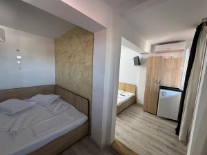 a small room with a bed and a small bathroom at Casa Bella in Eforie Sud
