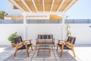 two chairs and a table on a patio at Koula's Aegina in Perdhika