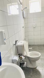 モンバサにあるNyali beach cosy homeのトイレと洗面台を備えた白いバスルーム
