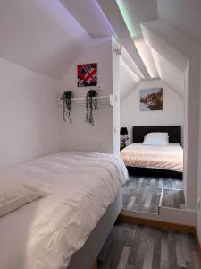 a bedroom with two beds in a attic at La grange en pierre - chic & piscine privée in Queyssac