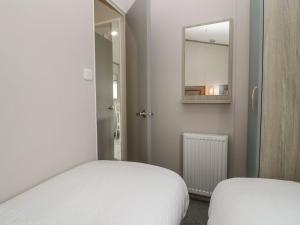 a small room with a bed and a mirror at Yew in Denny