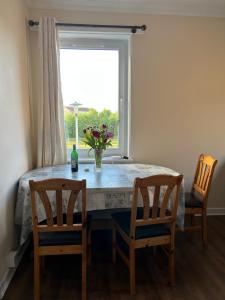 Una mesa de comedor con dos sillas y una ventana. en Spacious room close to tram, en Edimburgo