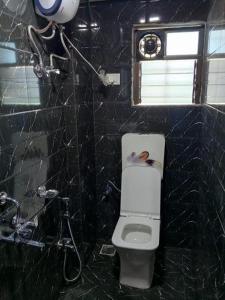 a black bathroom with a toilet and a shower at Via Sagar Residency in Navi Mumbai