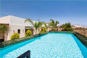 a large blue swimming pool in front of a house at Villa Olympia, 7 BR, for up to 22 persons, 400 meters from the long sandy beach in Kavros