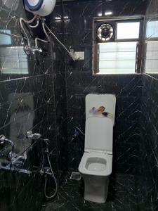 a bathroom with a toilet and a shower at Via Sagar Residency in Navi Mumbai