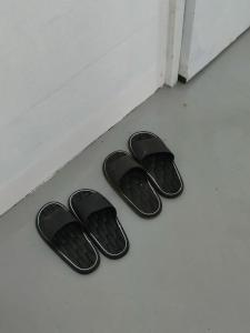 a pair of black flip flops sitting on the floor at Kitten's Corner Bed & Breakfast in Roxas City