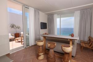 a living room with a table and a view of the ocean at WhiteLace Resort in Jbeil