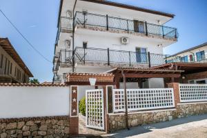 a white house with a fence and a balcony at Vila Amir Vama Veche in Vama Veche