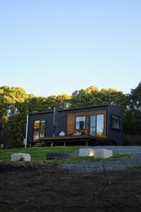 a black tiny house on a gravel lot at Milfarrago Farm Stay in Farnborough