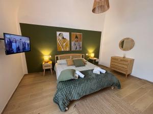 a bedroom with a bed with a green wall at Casa Vacanze La Donna di Cuori in Volterra