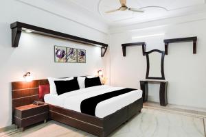 a bedroom with a black and white bed and a ceiling at HOTEL O 4 SQUARE A LUXURY ROOMS NEAR RDC MAIN MARKET in Ghaziabad