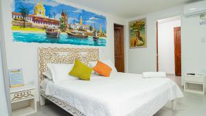 a bedroom with a bed with a painting on the wall at CASA PLAYA JAMES in La Boquilla