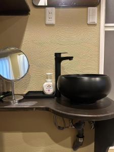 a bathroom counter with a black sink and a mirror at 藤通天阁景观民宿 in Osaka +35 photos
