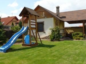 un parque infantil con un tobogán en un patio en Privat INKA, en Liptovský Mikuláš