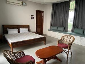 MohaliIT City Luxe Homestay-Secure & Comfortable Stay in Mohali的一间卧室，里面有一张床、两把椅子和一张桌子 更多62张照片