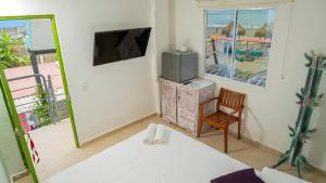 a room with a bed and a tv and a chair at CASA PLAYA JAMES in La Boquilla