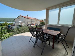 a patio with a table and chairs on a balcony at Kristina Apartmanház in Dobrinj