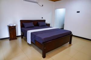 una camera da letto con un letto grande con lenzuola blu di Dila Beach Resort a Trincomalee