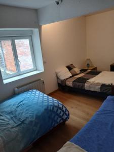 a bedroom with two beds and a window at Chic et relax familial in Montmarault