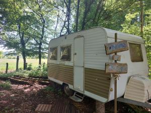an old white trailer with a sign that says online at Belltent La Jonquille in Hurecourt +6 photos