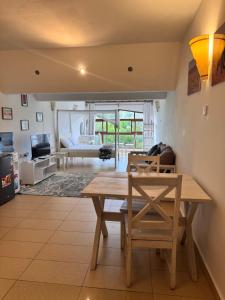 a living room with a wooden table and chairs at Goldensun Resort Studio in Diani Beach