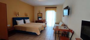 a hotel room with a bed and a television at Amalia in Paleo Tsifliki