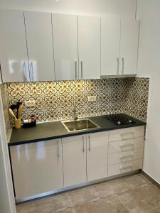 a kitchen with white cabinets and a sink at Casa M- Studio #1 - Brand New in Herceg-Novi