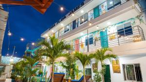 a building with palm trees in front of it at CASA PLAYA JAMES in La Boquilla