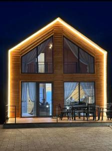 乔尔蓬阿塔Lake Villas Issyk-Kul Opening 2024的一座建筑物，前面有一张桌子和几张长凳