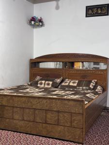 ein großes Holzbett in einem Zimmer in der Unterkunft Mir heritage in Srinagar