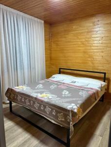 乔尔蓬阿塔Lake Villas Issyk-Kul Opening 2024的带木墙的房间里的一张床