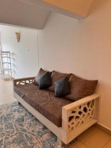 a couch in the corner of a room at Goldensun Resort Studio in Diani Beach +6 photos