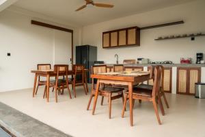 a kitchen with wooden tables and chairs in a room at Rasa Ubud Yoga Coliving in Ubud