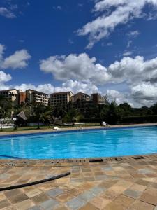 a large swimming pool with buildings in the background at Goldensun Resort Studio in Diani Beach