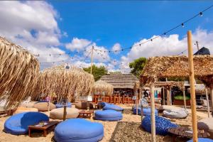 plaża z niebieskimi poduszkami i krzesłami na piasku w obiekcie Thelfi Luxury studio in Attica - close to varkiza beach - Sea view w mieście Vari